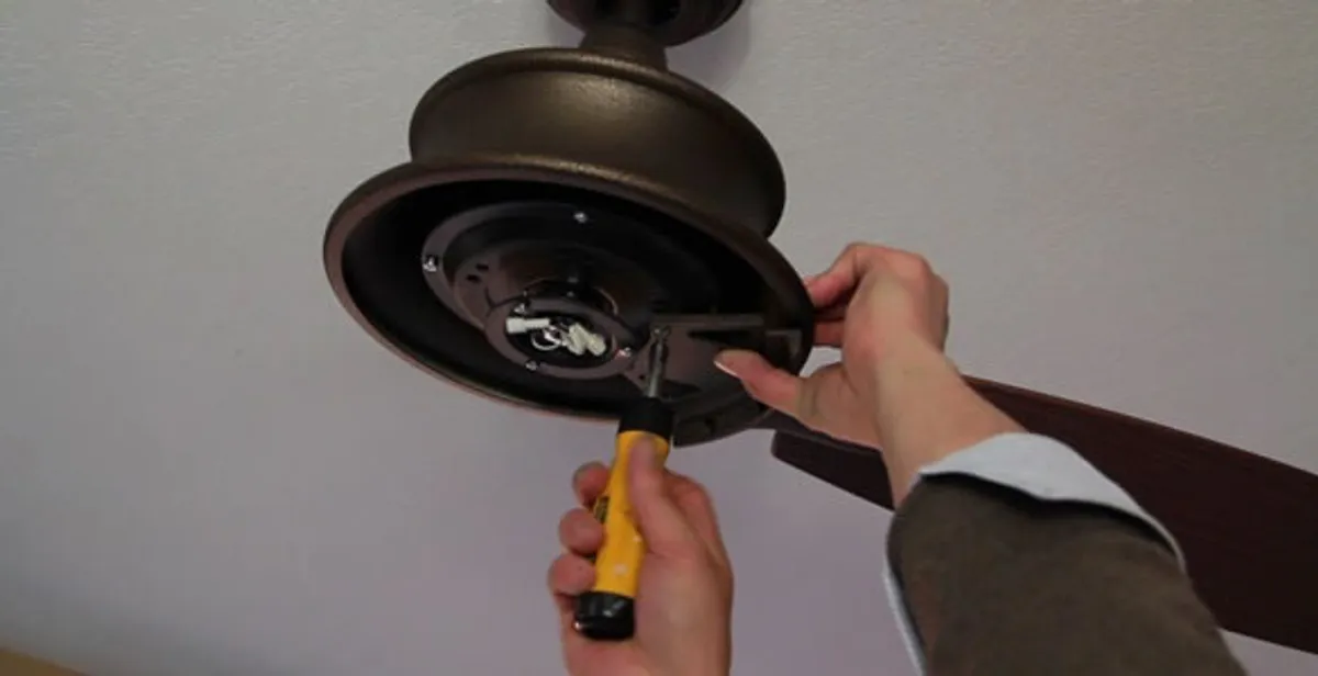 Electrician installing ceiling fan mounting bracket and fixture in Stockton, CA