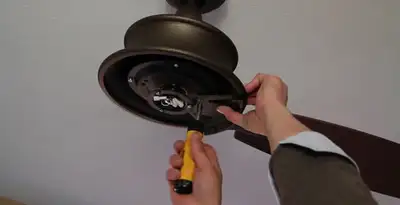 Electrician installing ceiling fan mounting bracket and fixture in Stockton, CA