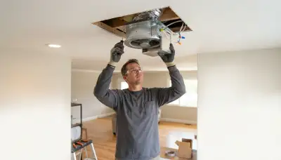 Electrician installs an insulated whole-house fan damper in a Stockton, CA ceiling opening