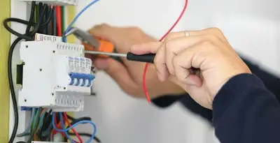 Electrician installing and adjusting circuit breakers in an electrical panel in Stockton, CA